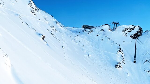 Timelapse overlooking the Tortin sector in Verbier as freeriders carve fresh lines across deep powder beneath the ski lifts on a perfect powder day.