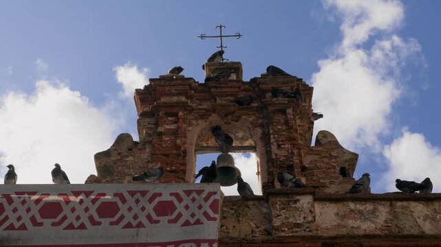 Pigeons Sit on Bell Tower of Historic Capilla del Cristo in Old San Juan, Puerto Rico - Tilt Down - UHD 4K