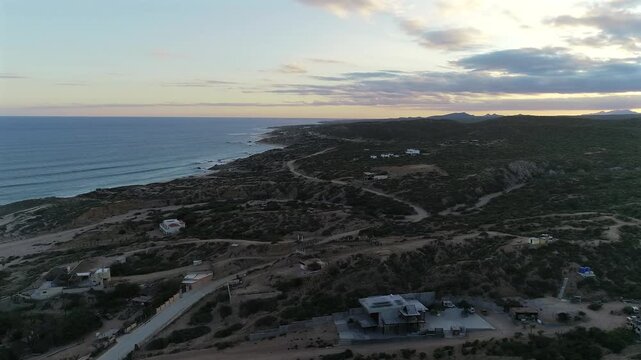 Drone pulls back farther over the land west of Nine Palms, rising and turning slowly to the right to reveal more of the lush desert and coastline, with the beginning of a mountain range appearing on t