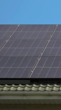 Solar panels installed on the roof of a city building. Concept of eco friendly and alternative power source - Vertical Video
