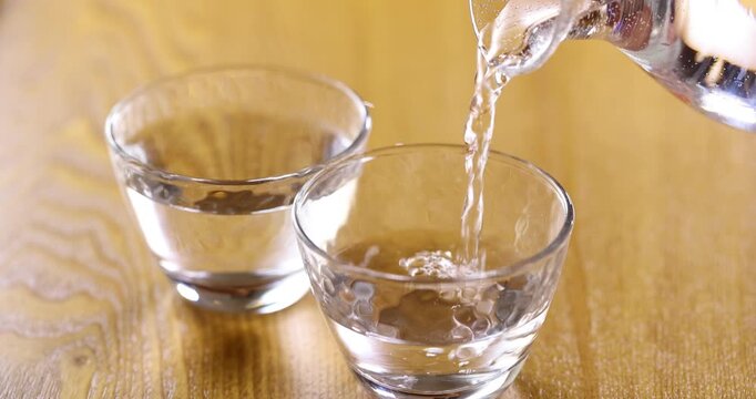 冷酒をガラスのお猪口に注ぐ