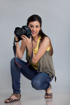 Full length of smiling female photographer with camera in her studio 