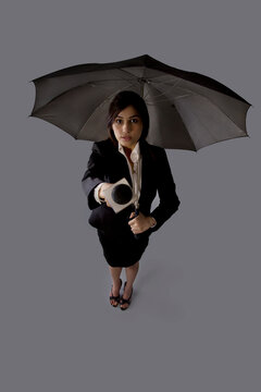 Portrait of young woman with umbrella asking comment 