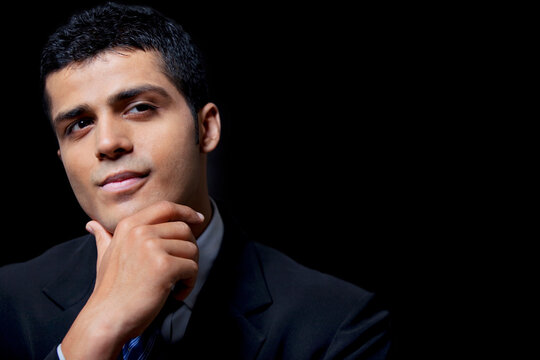 Confident young business man over black background 