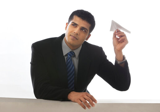 Young executive about to toss a paper airplane 