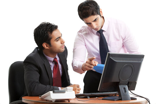 Businessmen executives discussing while looking at computer 