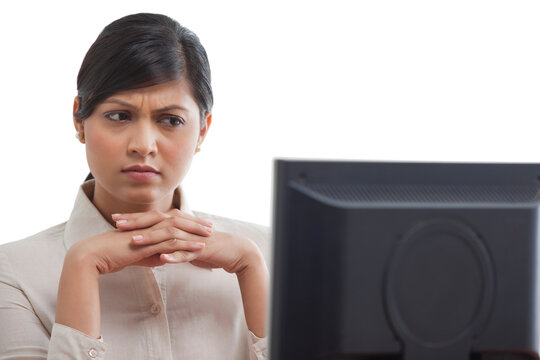 Businesswoman concentrating while looking at monitor screen 