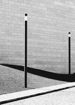 Minimalist lamp posts cast long dark shadows