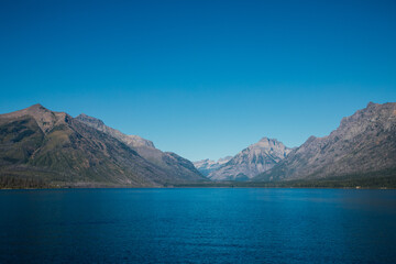 Fototapeta premium Mountain range over deep blue Lake McDonald