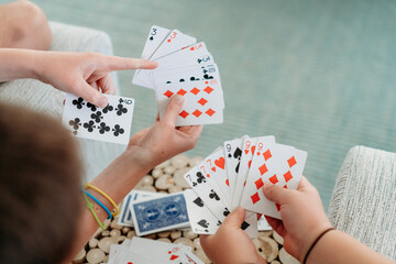 Fototapeta premium Overhead view of friends playing a card game