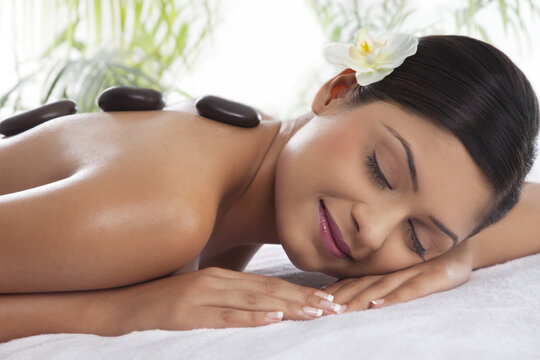 Smiling young woman getting lastone treatment 