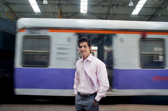 Businessman standing next to a train compartment 