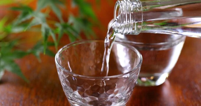 冷酒をガラスのお猪口に注ぐ