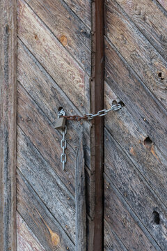 Puerta de madera antigua cerrada con cadena y candado