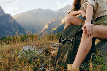 Woman lifestyle sitting outdoors on rock, relaxed posture, casual clothing, mountain landscape...