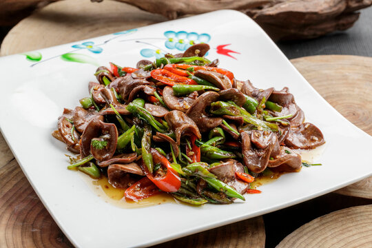 Two-color stir-fried pork kidney slices with green peppers, presented in elegant tableware