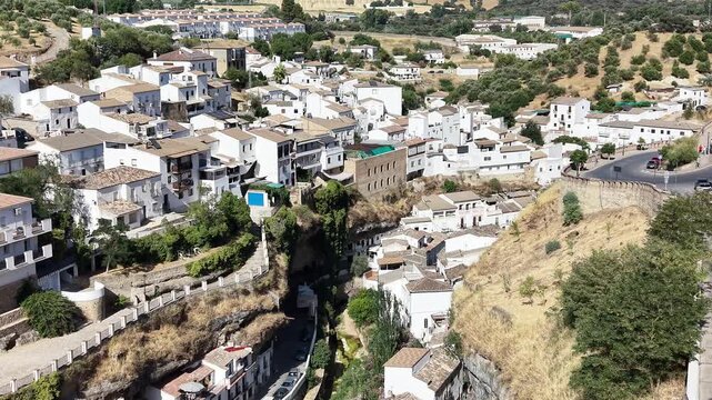 Aerial view of the white houses built into the rocky cliffs of the historic village of Setenil de las Bodegas, Andalusia, Spain.