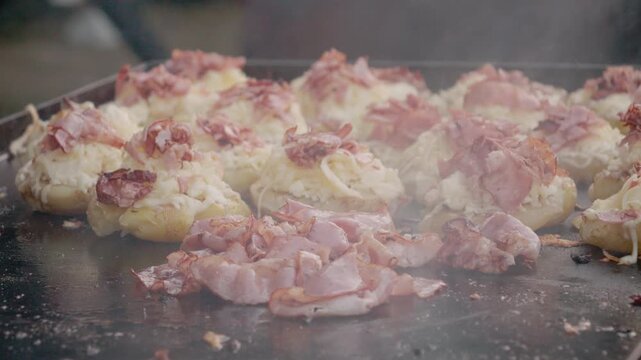 People enjoy delicious potato with cheese and ham at a street food festival in Bukovina. The smell of cooking fills the air as food is prepared.