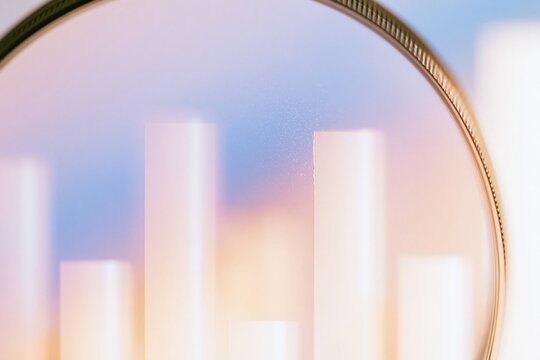 Magnifying glass hovering over a field of silver chart bars with a soft lilac haze and polished finish for data analytics and market research