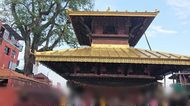 Footage of the historic Manakamana Temple in Nepal, showcasing its traditional multi-tiered pagoda-style architecture, ornate golden roof decorations, intricate wood carvings, and surrounding heritage