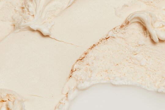 Vanilla ice cream with creamy ridged textures and vanilla bean seeds, showing a frozen, sweet surface for dessert backgrounds and food ads
