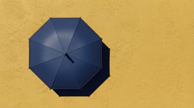 Top View of a Dark Blue Beach Umbrella Casting a Long Sharp Shadow on Warm Golden Sand Perfect for Relaxing Summer Vacation and Coastal Concepts