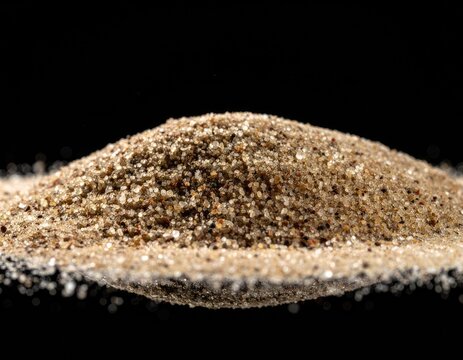A pile of fine-grained sand with a dark background.