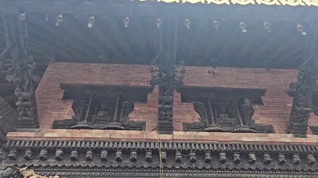 Footage of the historic Manakamana Temple in Nepal, showcasing its traditional multi-tiered pagoda-style architecture, ornate golden roof decorations, intricate wood carvings, and surrounding heritage