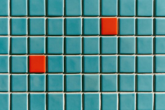 Small square ceramic tiles in bright sky blue with occasional orange accents, featuring a glossy glazed finish for a backsplash material backdrop