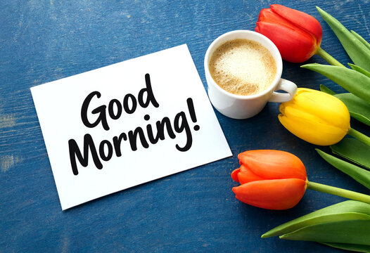 Bright good morning greeting with a cup of coffee tulips and a handwritten note on table