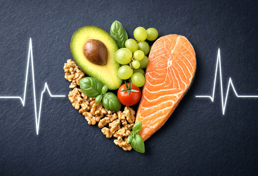 Healthy heartshaped arrangement of fresh foods including avocado salmon grapes and nuts for heart health concept