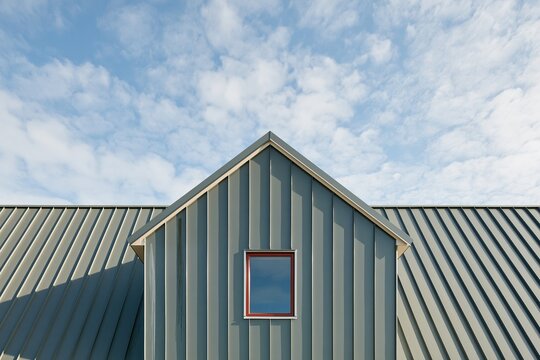 Metal standing-seam roofing on a house gable with a red window, featuring industrial textures and crisp lines for construction and roofing services