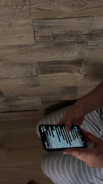 Woman scrolling through social media feed on a smartphone at home, reading news, browsing content, and searching for information on her mobile device using the internet