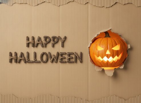 Happy halloween greeting card design with a carved scary pumpkin lantern on a textured brown background