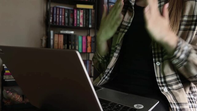 Woman actively gesturing during an online therapy session with a therapist, discussing mental health and seeking professional psychological support via video call on her laptop