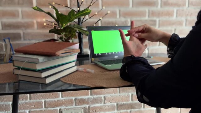 Female therapist gesticulating during an online therapy session with a patient using a green screen laptop for mental health consultation and psychological support
