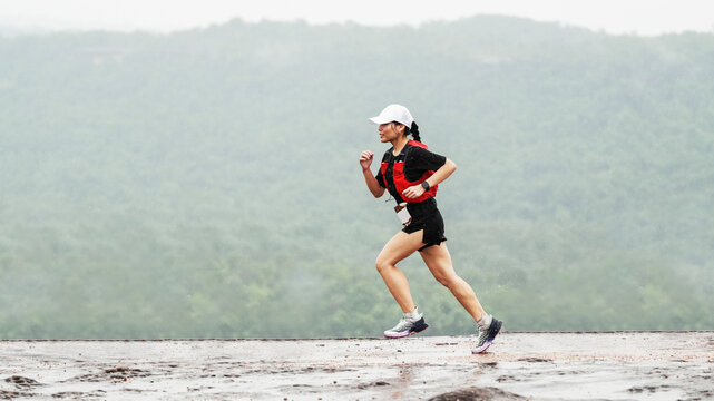 Female trail runner exercising outdoors with scenic mountain landscape and copy space