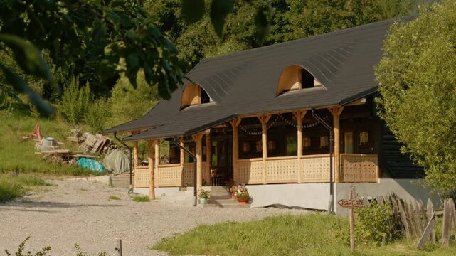 A traditional house located in Bucovina. The house features wooden design elements and sits surrounded by green landscapes. Visitors can see local architecture up close.