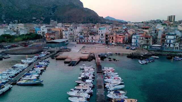 Aerial sunrise perspective of the coastal village, marina, and docked boats in Sferracavallo, Palermo, Sicily, Italy