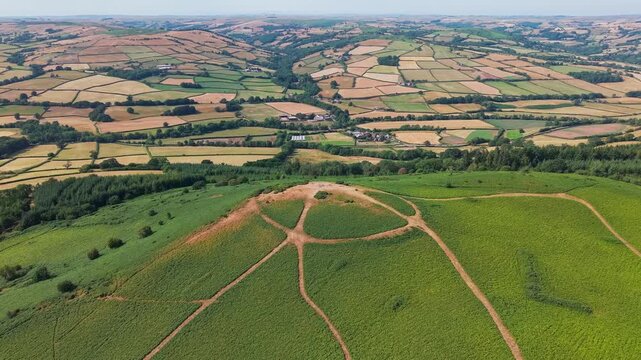 Aerial view of Twyn y Gaer Iron Age hillfort on Mynydd Illtyd in the Brecon Beacons, Wales, surrounded by green bracken and rural patchwork fields