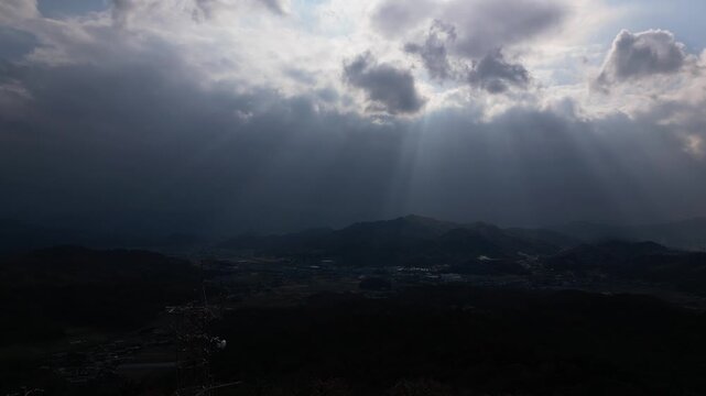 Cinematic Drone Aerial View of Sun Rays Breaking Through Clouds Over the Landscape