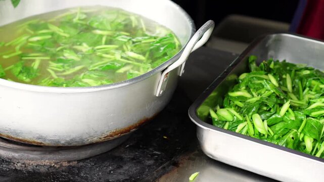 4K Video of Scooping Blanched Chinese Kale from Hot Water with Wire Strainer
