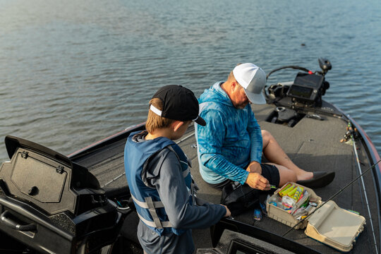 Father and son preparing fishing gear on a boat