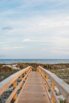 Wooden boardwalk leading over sand dunes to the ocean