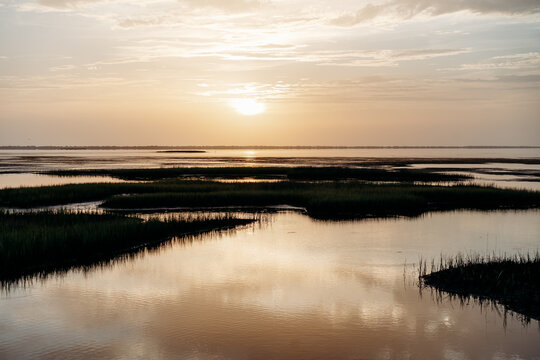 Sun rising over a tranquil coastal salt marsh
