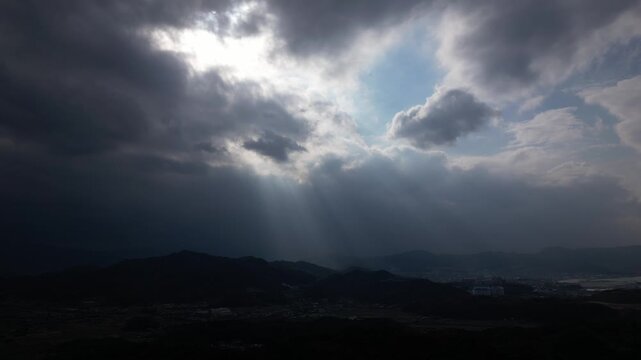 Cinematic Drone Aerial View of Sun Rays Breaking Through Clouds Over the Landscape