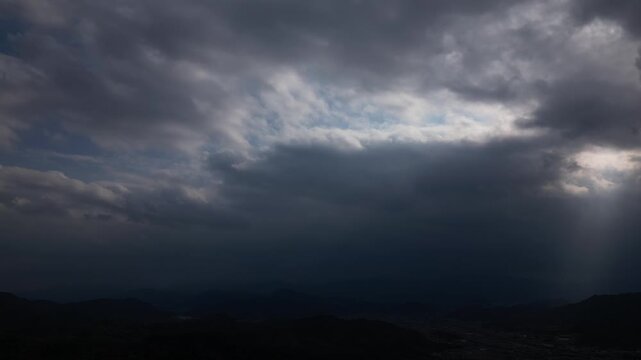 Cinematic Drone Aerial View of Sun Rays Breaking Through Clouds Over the Landscape