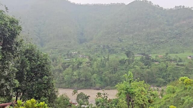 High-angle aerial view from the Manakamana cable car, looking down over dense green forest and rugged hillside terrain near the famous Manakamana Temple in Nepal.