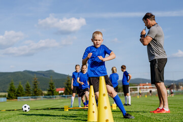 Fototapeta premium Young athletes training footwork and coordination on soccer field.