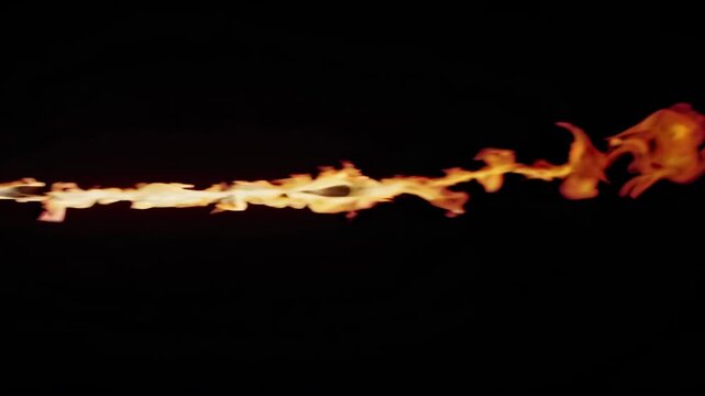 Flames shooting from a nozzle create a fiery trail in a dark environment, showcasing the dynamic movement and intensity of fire in a visually striking manner